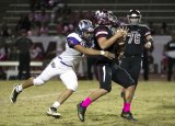 Lemoore's Frankie Oregel sneaks up on the Pioneer quarterback in Friday's 49-37 loss to Mt. Whitney High School.